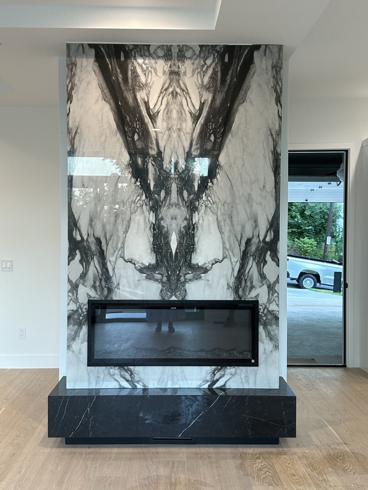 Book-matched marble fireplace feature wall by Donya LLC