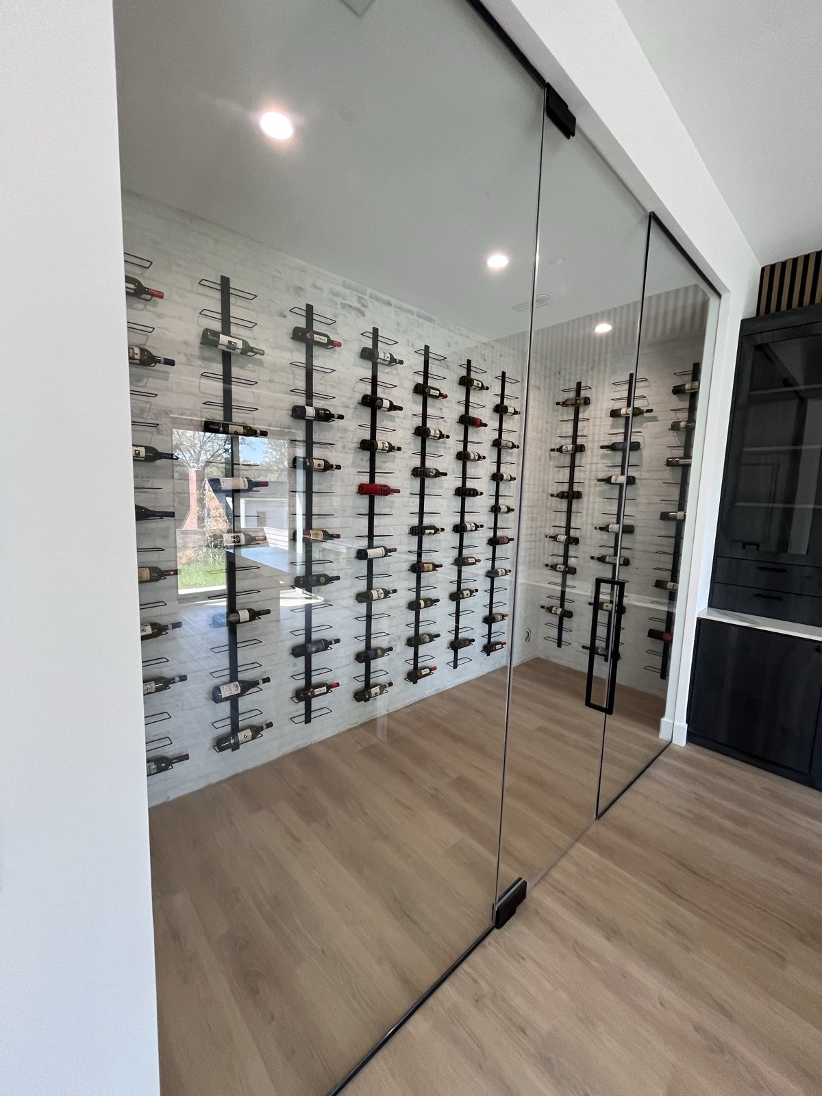 Glass-enclosed custom wine room by Donya LLC